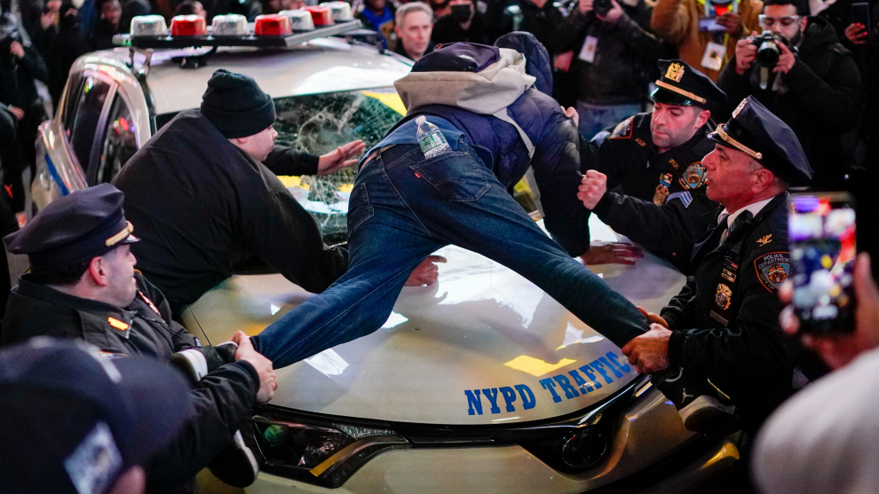A protestor stands on top of a police vehicle, on the day of the release of a video showing police officers beating Tyre Nichols, the young Black man who died three days after he was pulled over while driving during a traffic stop by Memphis police officers, in New York, U.S., January 27, 2023. REUTERS/Eduardo Munoz MEMPHIS-POLICE/