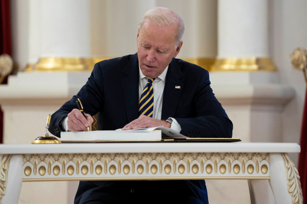U.S. President Joe Biden signs a guest book as Ukrainian President Volodymyr Zelenskiy watches at Mariinsky Palace on an unannounced visit in Kyiv, Ukraine, February 20, 2023. Evan Vucci/Pool via REUTERS UKRAINE-CRISIS/BIDEN