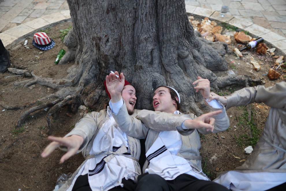 Ultra-Orthodox Jewish men rest as they take part in a celebration in Mea Shearim neighbourhood during the Jewish holiday of Purim, in Jerusalem, March 8, 2023. REUTERS/Ammar Awad RELIGION-PURIM/JERUSALEM