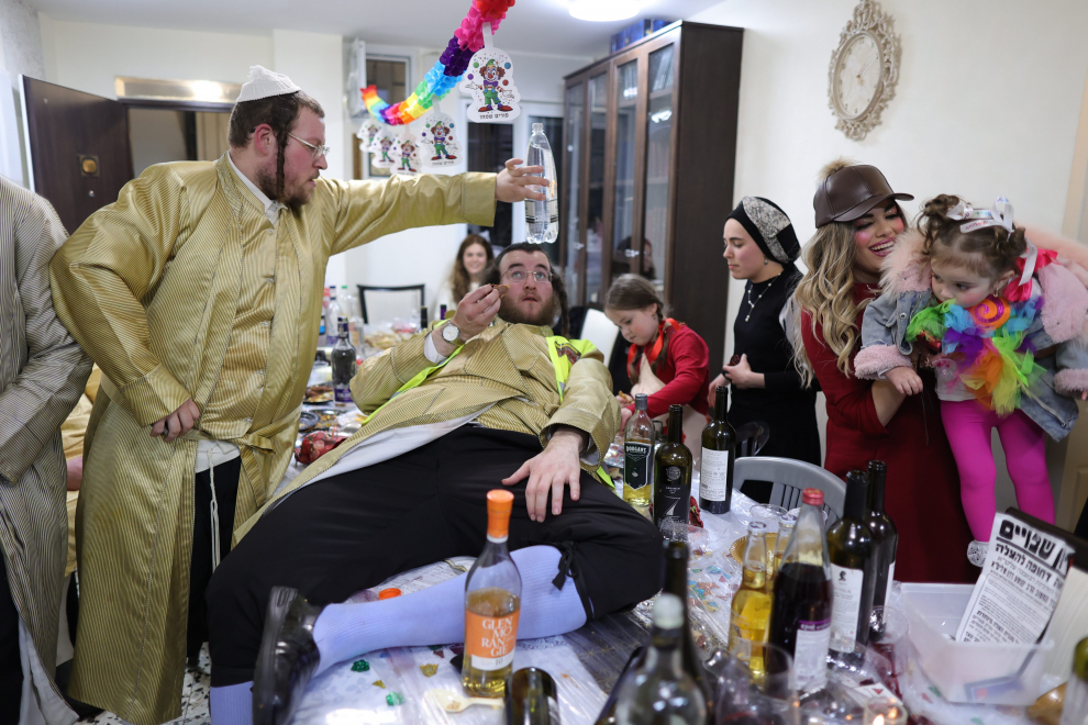 Ultra-Orthodox Jewish men rest as they take part in a celebration in Mea Shearim neighbourhood during the Jewish holiday of Purim, in Jerusalem, March 8, 2023. REUTERS/Ammar Awad RELIGION-PURIM/JERUSALEM