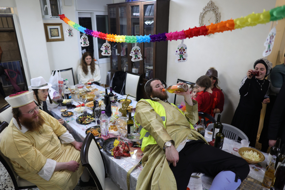 Ultra-Orthodox Jewish men rest as they take part in a celebration in Mea Shearim neighbourhood during the Jewish holiday of Purim, in Jerusalem, March 8, 2023. REUTERS/Ammar Awad RELIGION-PURIM/JERUSALEM
