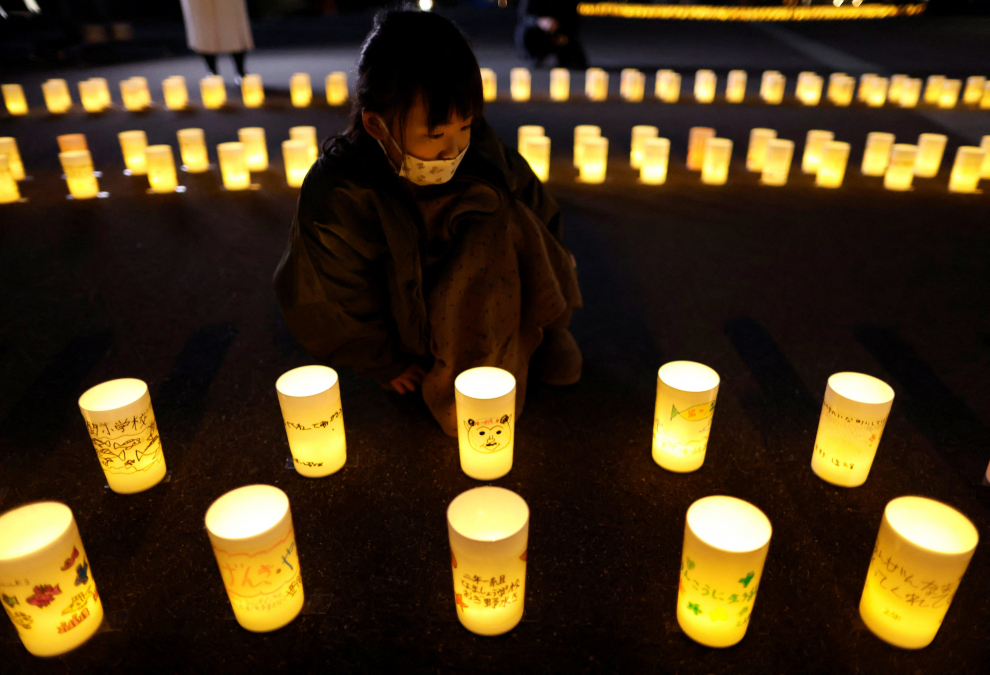 A man with a child on his shoulders looks at yellow handkerchiefs bearing messages in support of people in areas hit by the 2011 earthquake and tsunami, which are hanged at Iwaki 3.11 Memorial and Revitalisation museum, to mark the 12-year anniversary of the disaster, in Iwaki, Fukushima prefecture, Japan, March 11, 2023.  REUTERS/Issei Kato JAPAN-FUKUSHIMA/ANNIVERSARY