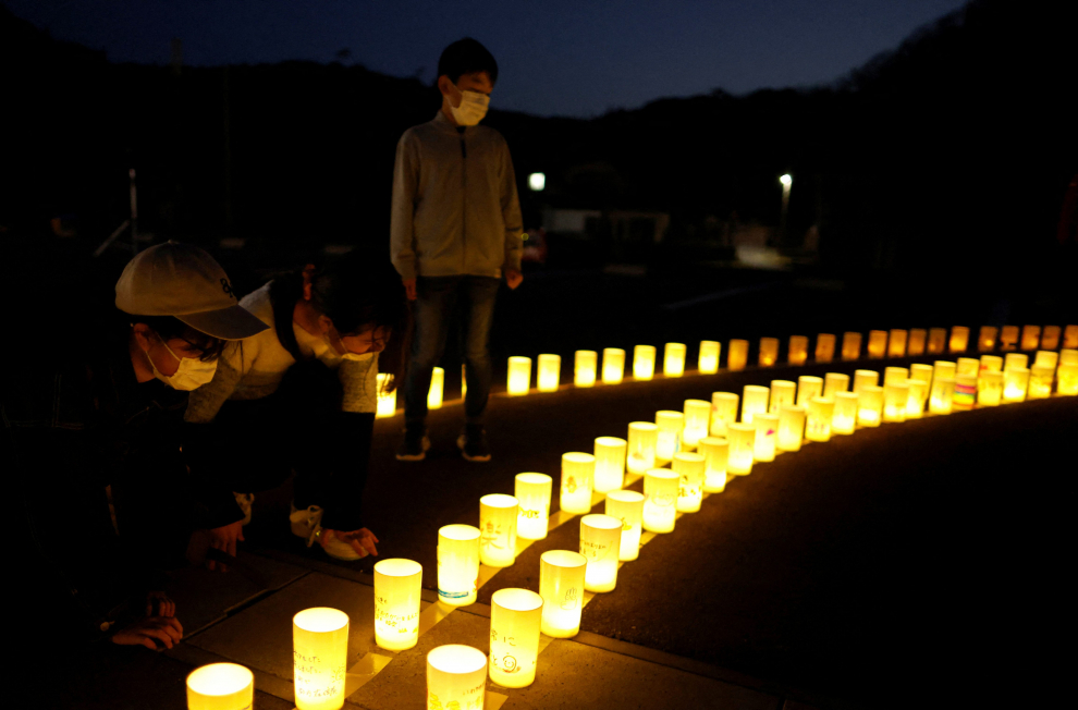 A girl looks at candles bearing messages in support of people in areas hit by the 2011 earthquake and tsunami, during a candlelight vigil at Iwaki 3.11 Memorial and Revitalisation museum to mark the 12-year anniversary of the disaster, in Iwaki, Fukushima prefecture, Japan, March 11, 2023.  REUTERS/Issei Kato JAPAN-FUKUSHIMA/ANNIVERSARY