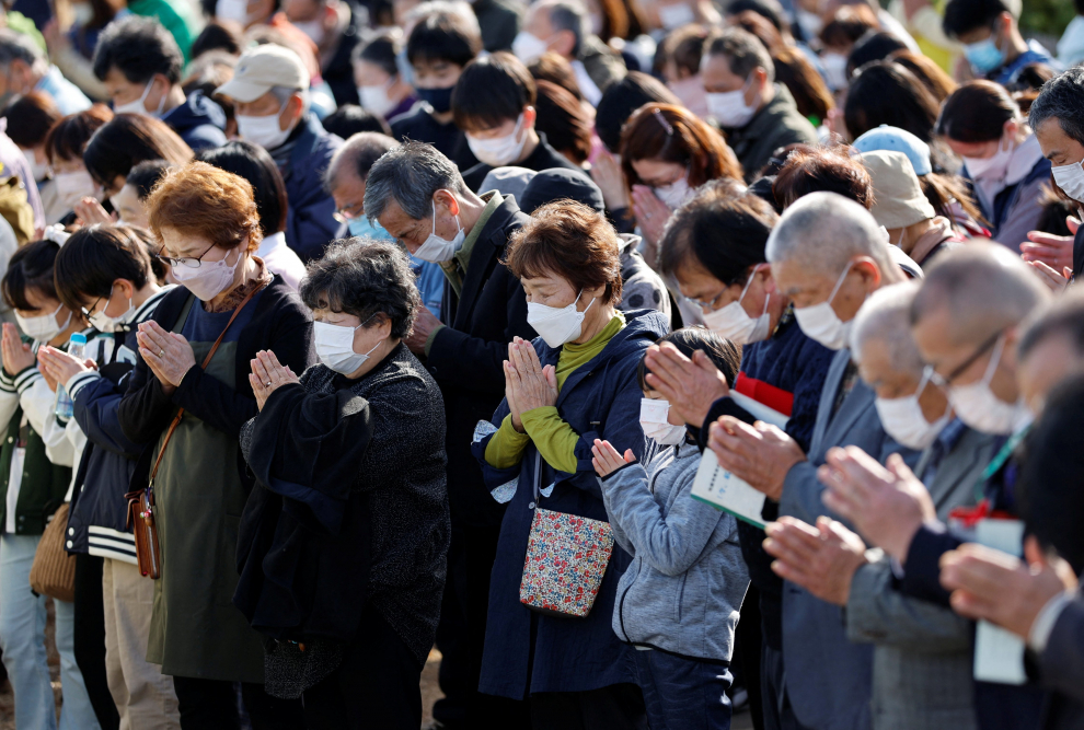 People observe a moment of silence at 2:46 p.m. (0546 GMT), the time when the magnitude 9.0 earthquake and tsunami struck off Japan's coast that killed thousands and triggering the worst nuclear accident since Chernobyl, during its 12-year anniversary, in Iwaki, Fukushima prefecture, Japan, March 11, 2023. REUTERS/Issei Kato JAPAN-FUKUSHIMA/ANNIVERSARY