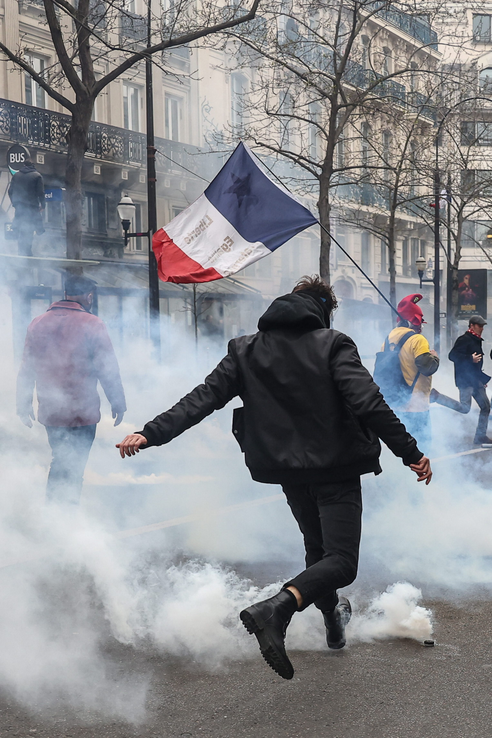 Paris (France), 23/03/2023.- A protester stands in tear gas fumes during clashes with anti-riot police during a demonstration against the government pension reform in Paris, France, 23 March 2023. Protests continue in France after the French prime minister announced on 16 March 2023 the use of Article 49 paragraph 3 (49.3) of the French Constitution to have the text on the controversial pension reform law be definitively adopted without a vote in the National Assembly (lower house of parliament). The bill would raise the retirement age in France from 62 to 64 by 2030. (Protestas, Francia) EFE/EPA/MOHAMMED BADRA
 FRANCE PENSIONS PROTEST