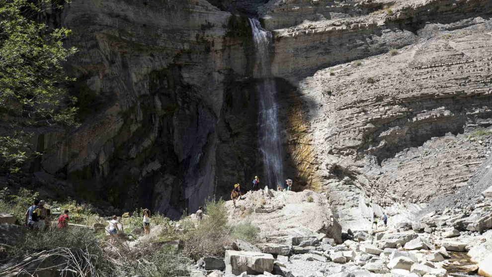 Unos turistas en la cascada de Sorrosal en Broto.