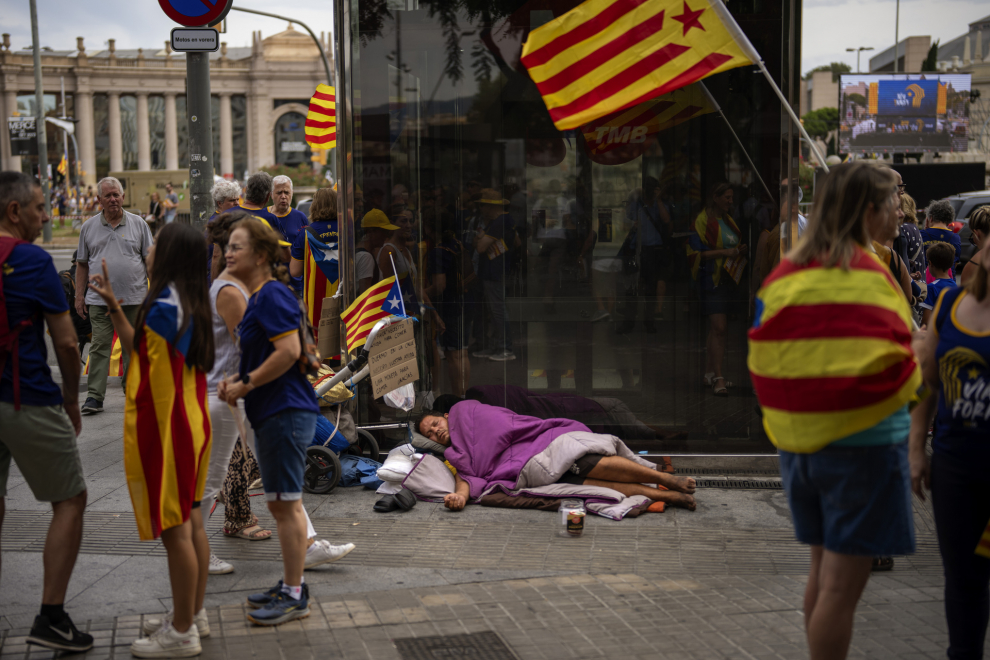 Manifestantes sostienen banderas de la independencia, junto a un hombre que duerme en el suelo.
