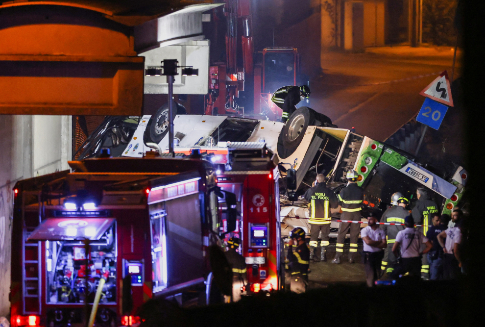A firefighter works near a coach after it crashed off an overpass near Venice, in Mestre, Italy, October 4, 2023. REUTERS/Claudia Greco ITALY-COACH/CRASH