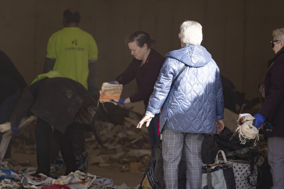 Vecinos del edificio derrumbado en Teruel buscan objetos personales entre los escombros.
