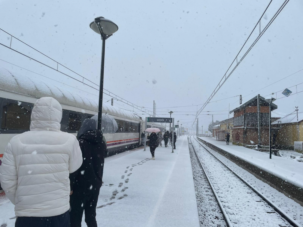Los pasajeros en la parada de Grisén tras llevar horas parados a causa de la nieve.