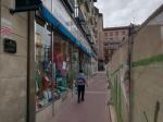 Una mujer pasa junto a Comercial Algodonera en una vallada calle del Teniente Coronel Valenzuela, afectada por las obras en la plaza de Salamero de Zaragoza