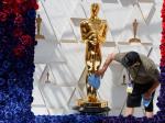 Un operario limpia una reproducción gigante del Óscar en los últimos preparativos para la gala de entrega