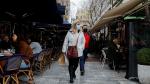 Dos personas caminan con mascarilla por una calle de Atenas, en una imagen de archivo.