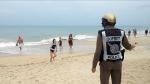 Un policía advierte de la prohibición de baño en la playa de Koh Samui antes de que comenzara la tormenta.