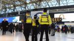 Agentes de policía montan guardia en la estación de tren de Waterloo, este martes en Londres (Reino Unido). La policía británica investiga tres paquetes con pequeños dispositivos explosivos caseros que fueron recibidos hoy en edificios de los aeropuertos