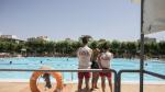 Una bañista conservaba este viernes con dos de los socorristas de las piscinas de Ciudad Jardín de Zaragoza.