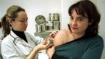 Una joven se vacuna contra el sarampión en un centro de salud.