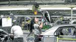 Operarios trabajan en una cadena de montaje de la factoría zaragozana de Opel PSA.