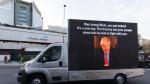 Una furgoneta transporta una pantalla con la imagen de Boris Johnson junto al hospital donde se encuentra ingresado.