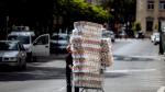 Un trabajador de un supermercado con rollos de papel higiénico.