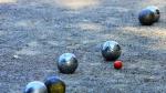 la petanca es un juego tradicional en el que el objetivo es lanzar bolas metálicas tan cerca como sea posible de una pequeña bola de madera