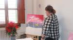 La zaragozana Pilar S., de 31 años, enseña uno de los cuadros que ha pintado en su piso del Actur, donde vive con otras tres compañeras con discapacidad.