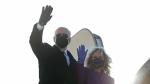 Joe Biden y su mujer, Jill, saludan desde la escalerilla del avión que los lleva a Washington.