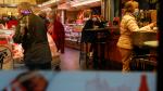 People shop as others sit at a bar as the coronavirus disease (COVID-19) outbreak continues in Madrid