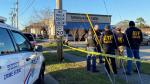 Law enforcement officers stand near the site of a shooting at a gun store in Metairie