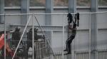 Un inmigrante intenta saltar la valla fronteriza de Ceuta, este martes.