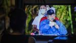 Una mujer sigue el discurso de Ortega en televisión