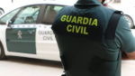 Un agente de la Guardia Civil junto a un vehículo oficial, en una imagen de archivo.