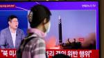Una persona mira un televisor que informa sobre el lanzamiento de tres misiles por parte de Corea del Norte, en Seúl.