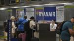 Varios pasajeros facturan sus maletas en los mostradores de Ryanair.