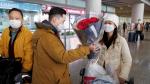 A man hands flowers to a woman after she came through the international arrivals gate at Beijing Capital International Airport after China lifted the COVID-19 quarantine requirement for inbound travellers in Beijing