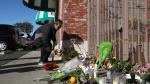 Gente dejando flores a las puertas del local donde ocurrió el tiroteo mortal