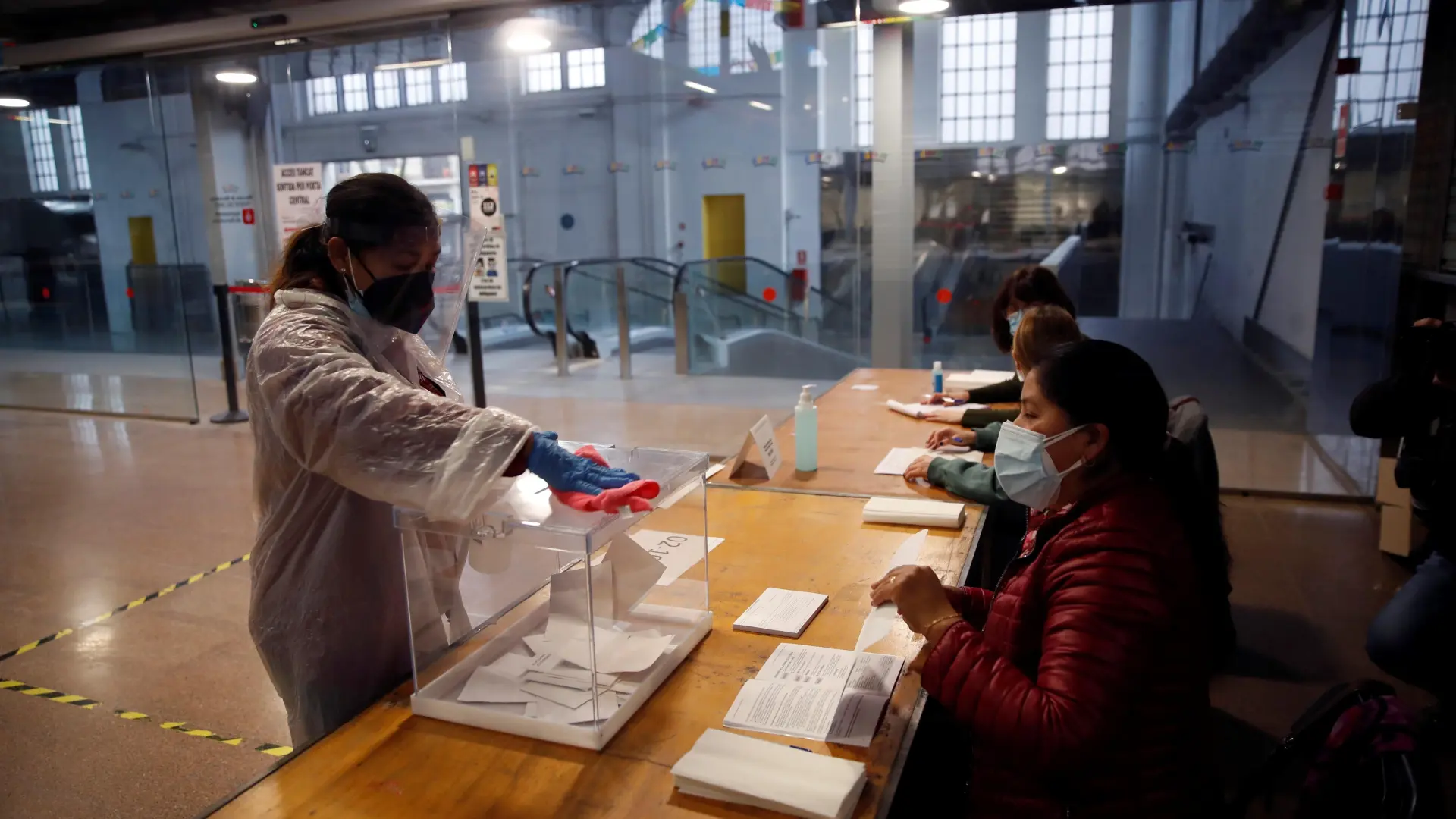 Una mujer limpia una urna en el colegio electoral situado en el Mercat del Ninot en Barcelona.