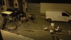 Momento en el que los ladrones intentan meter la caja registradora en el maletero del coche.