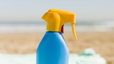 Envase de crema solar en la playa.