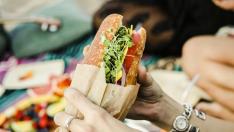 Woman eating a sandwich at the beach
