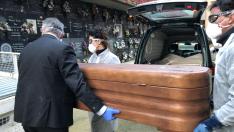 aru Madurga, Óscar Herrero y un trabajador de una funeraria trasladan el ataúd con un fallecido por coronavirus hasta el nicho.