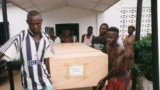 El ataúd con los restos de Miguel Gil es trasladado por trabajadores de la morgue de Freetown en mayo de 2000