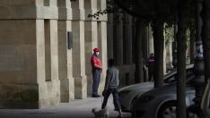 Un agente de la Policía Foral con mascarilla en los soportales de una céntrica calle de Pamplona.