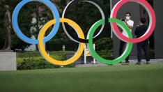Un hombre se toma fotos con los aros olímpicos junto al estadio donde se debían celebrar este año los juegos.
