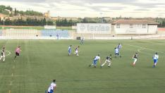 Un jugador del Haro Deportivo avanza con el balón mientras la defensa local trata de frenar su ataque.