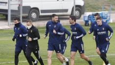 Zapater, primero a la izquierda con la cara cubierta del frío, ayer en el inicio del entrenamiento del Real Zaragoza.