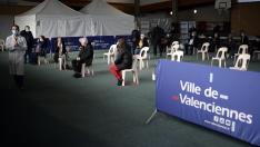 Varias personas esperan para vacunarse en un polideportivo en Valenciennes, Francia