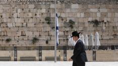Un judío ultraortodoxo pasa delante de una bandera a media asta en Jerusalén