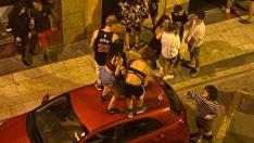 Jóvenes subidos a un coche aparcado en la calle Fita de Zaragoza