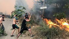 Varias personas tratan de apagar un fuego en Tizi Ouzou, al este de Argelia.